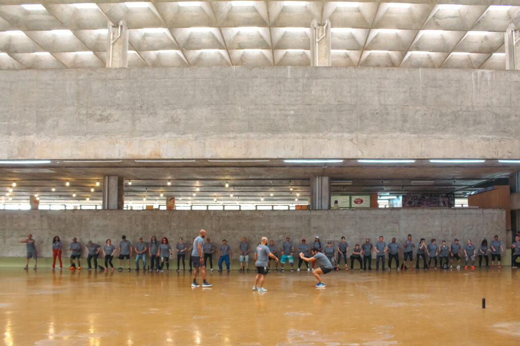 Pessoas realizando atividades físicas no interior do prédio da Faculdade de Arquitetura e Urbanismo e de Design.