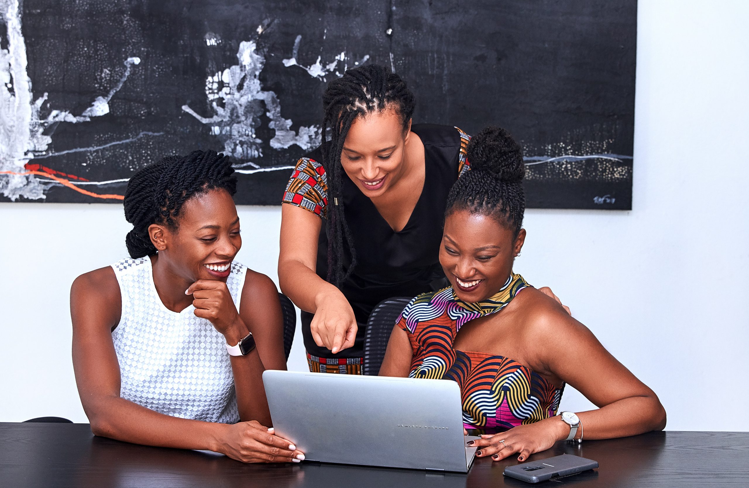 Três mulheres negras trabalhando em um computdor