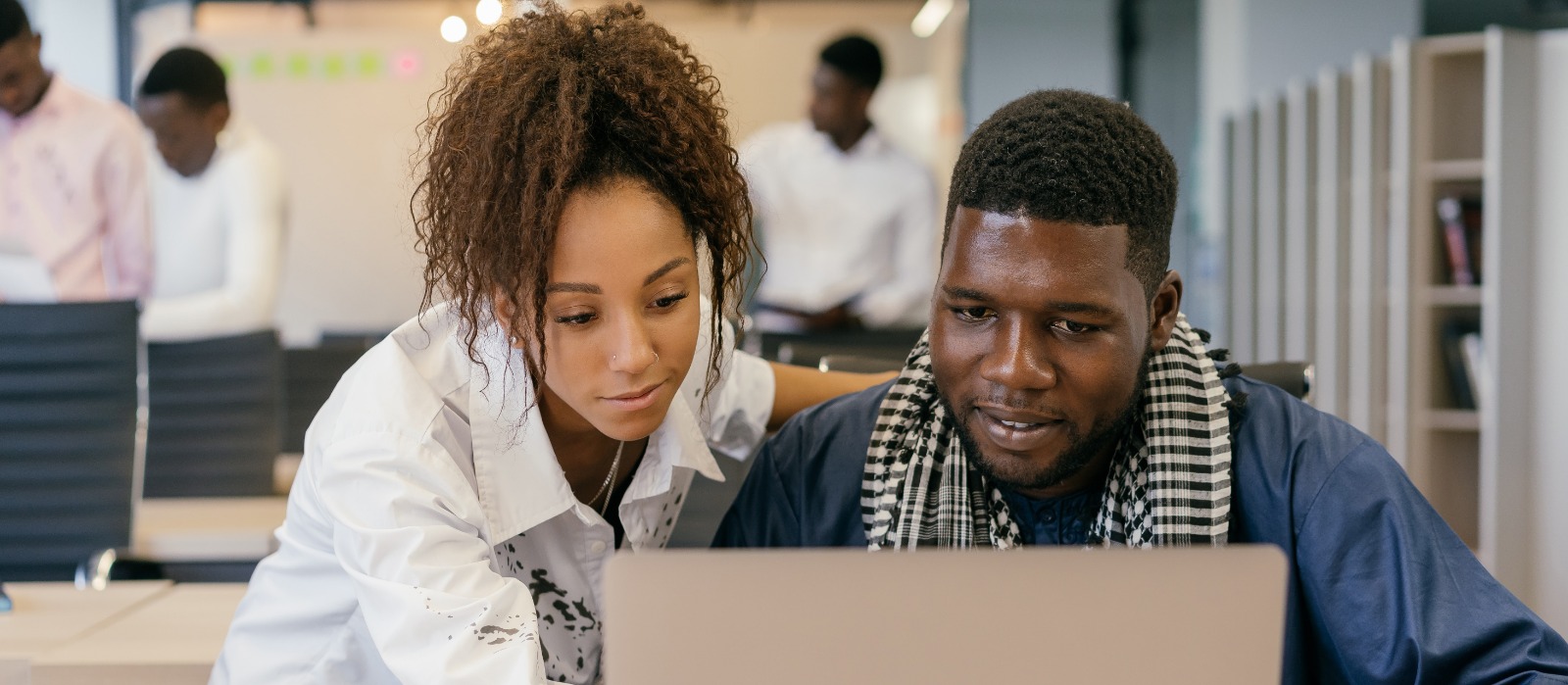 Homem e mulher negra trabalhando em um computador