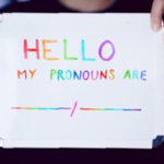 Pessoa segurando cartaz com o dizeres: "Hello, my pronouns are..."