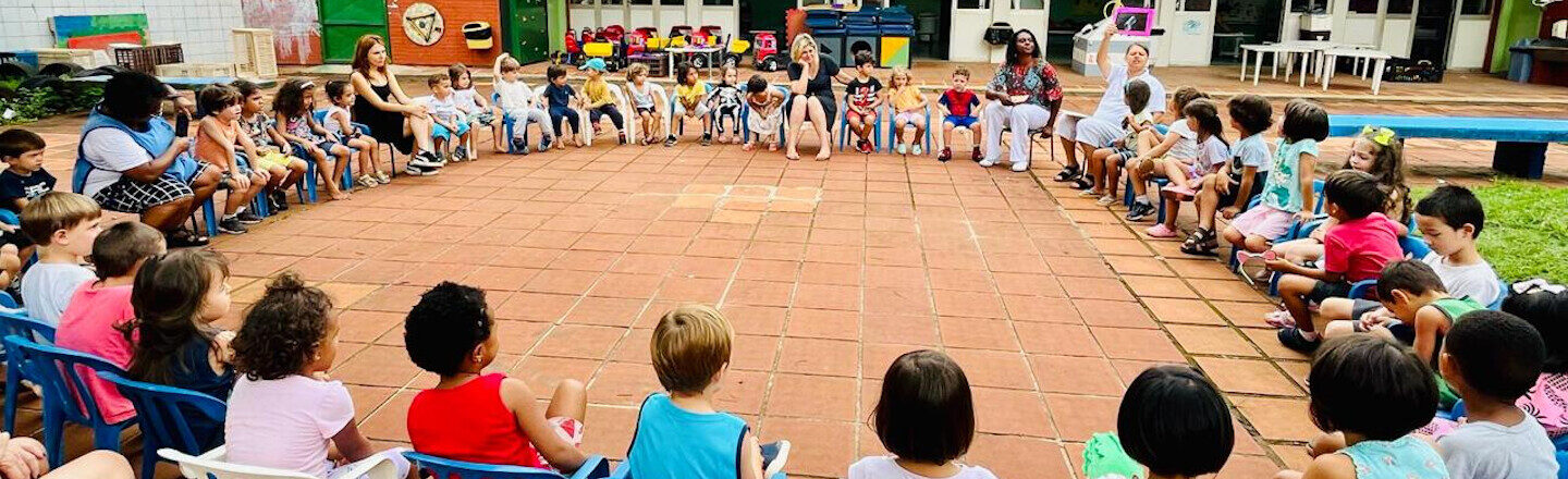 Crianças sentadas em roda.
